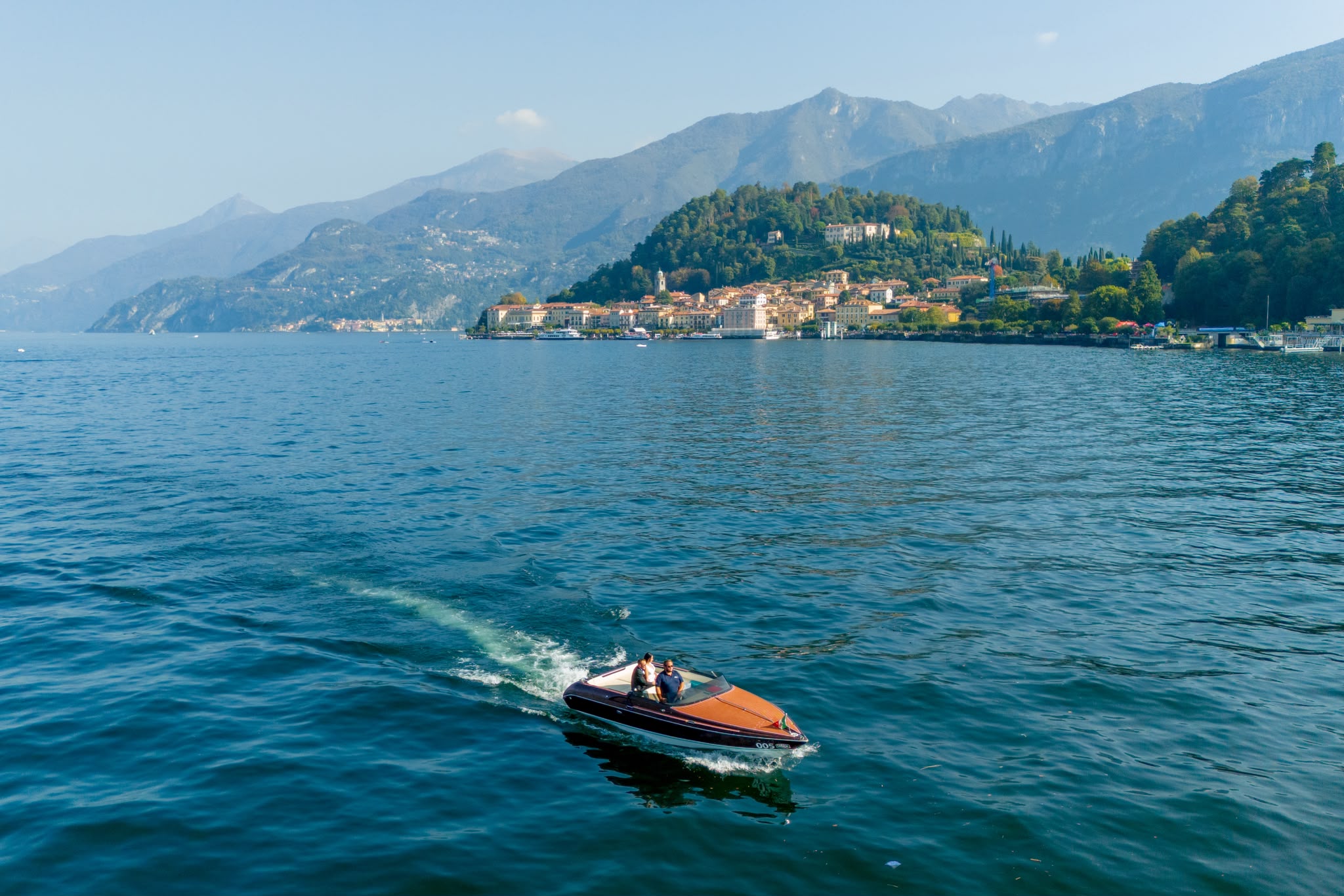 Venere wooden speedboat on Lake Como with villa gardens in the background